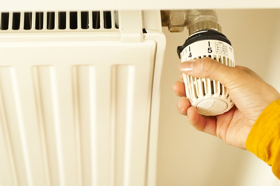 Asmuo koreguoja termostatą ir patikrina šildymo nustatymus po pirmos savaitės