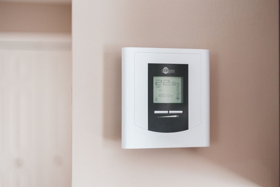 Žmogus prie išmaniojo energijos valdymo ekrano, stebima elektros gamyba ir vartojimas